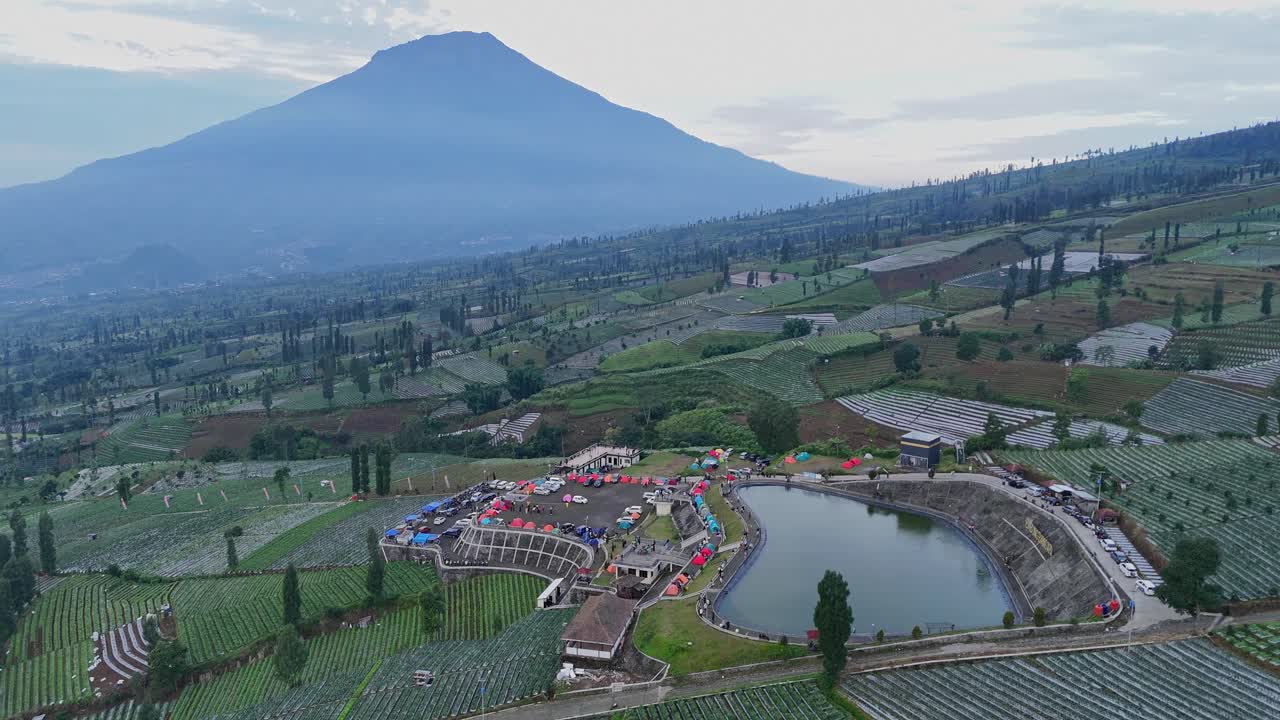 Aerial scenery of Embung Bansari with Mount Sumbing on the background. Water reservoir and tourist attraction on the slopes of Mount Sindoro, Indonesia.