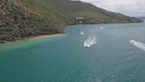 Aerial:-Waterskiing-on-surfboard-in-sunny-Knysna-Lagoon,-South-Africa