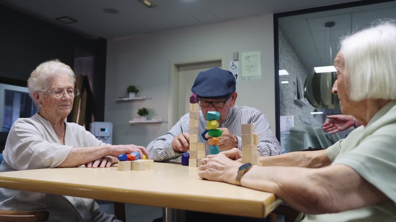 Elderly residents playing with wooden blocks in a care facility