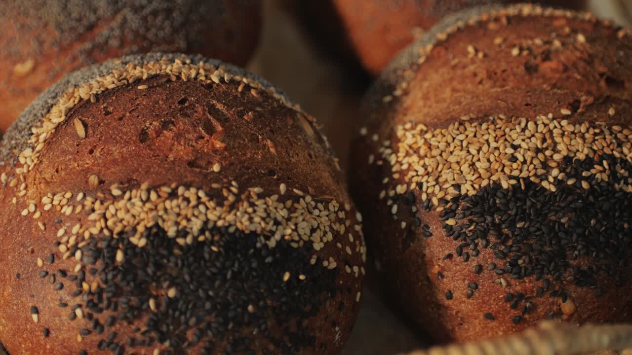 Fresh artesian bread on bakery shop close-up. Bread with black poppy garnish on top and white flour on top. Artisan bread is making by skill bakers using natural and high-quality ingredients. Food with health and flavour benefits.