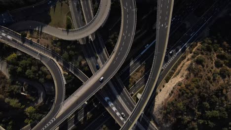 view down to the tangled system of roads, intersections and turns in an intertwined pattern with moving cars