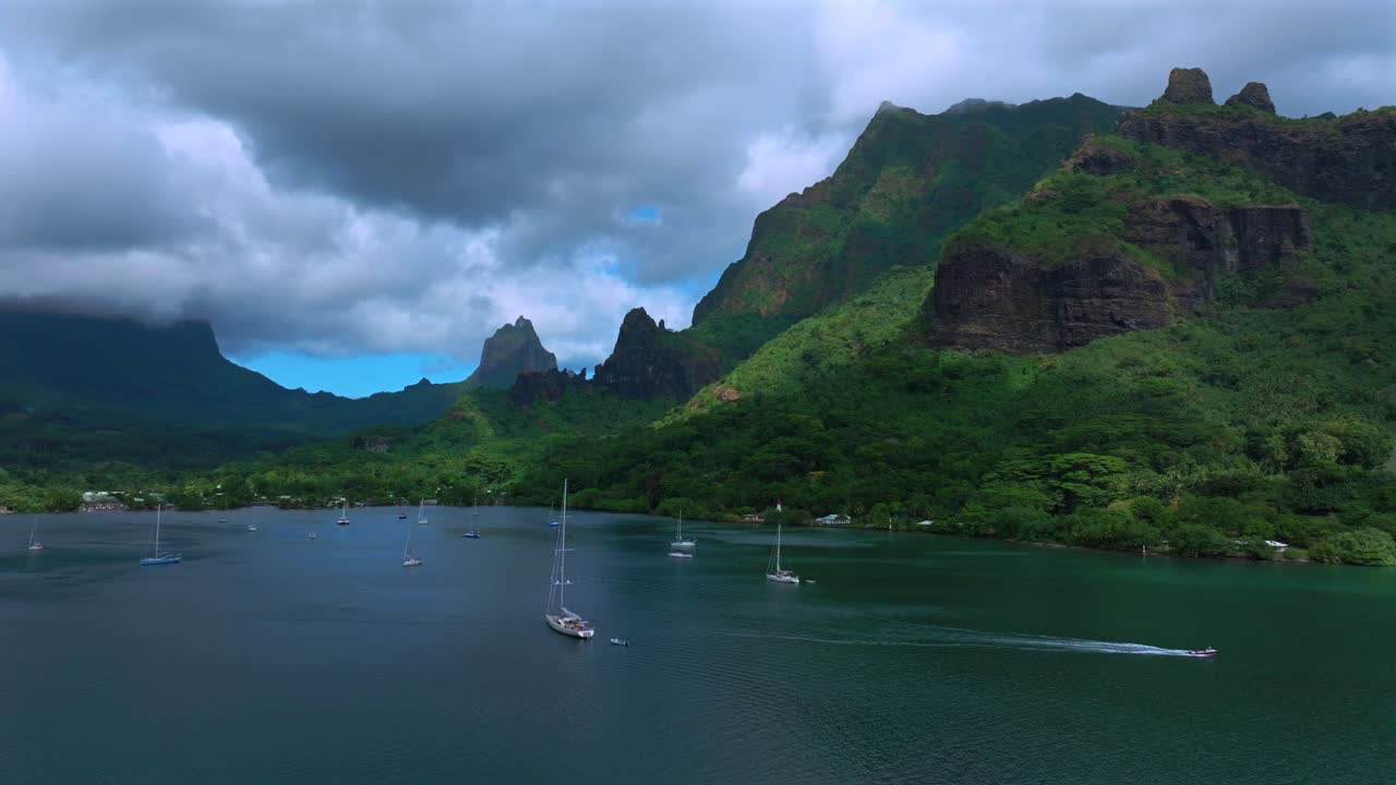 Mo'orea, Bora Bora, Franska Polynesien, flygdrönare, tropisk ö i södra Stilla havet, kryssning, motorbåtar, segelbåtar, Opunohu Bay, allmän strand, djupa turkosa laguner, taggiga toppar, solig morgon, cirklar höger.