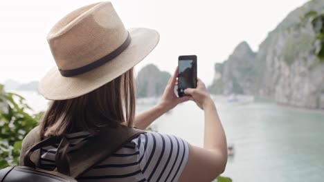 handheld view of tourist photographing with mobile phone