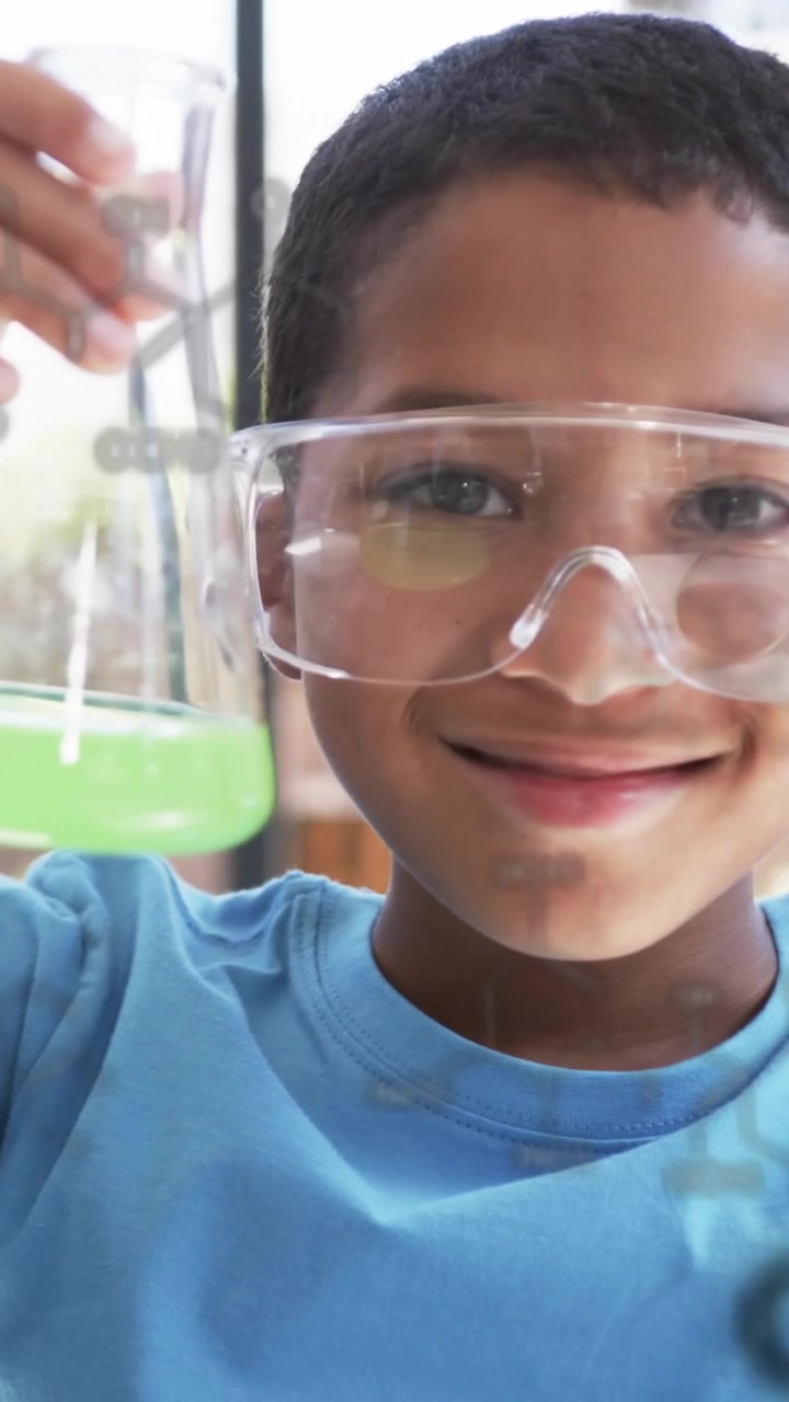 Conducting chemistry experiment, child holding flask with chemical formulas over