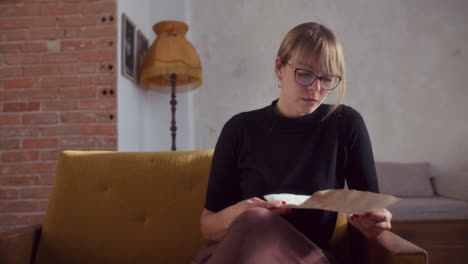 woman reading a letter at home