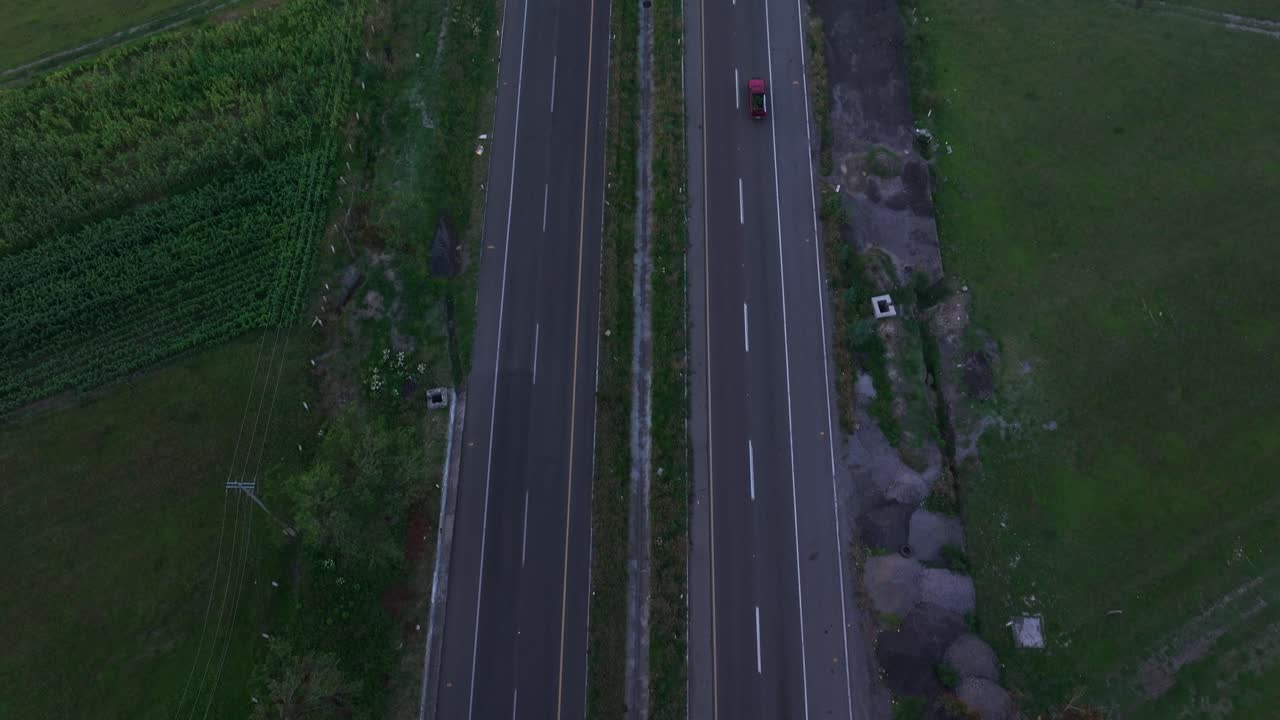 Drone bird's eye view tilt up along highway to reveal puebla city skyline mexico at dusk