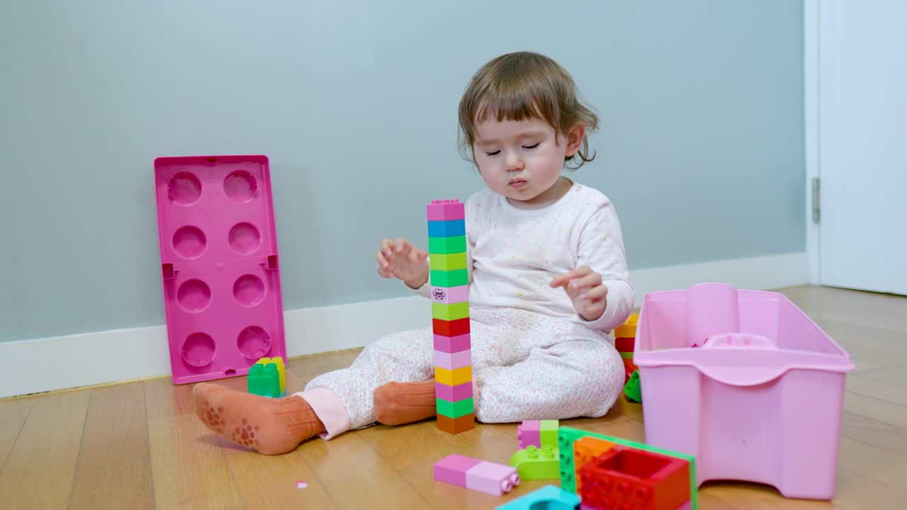 niña haciendo torre con coloridos bloques de construcción