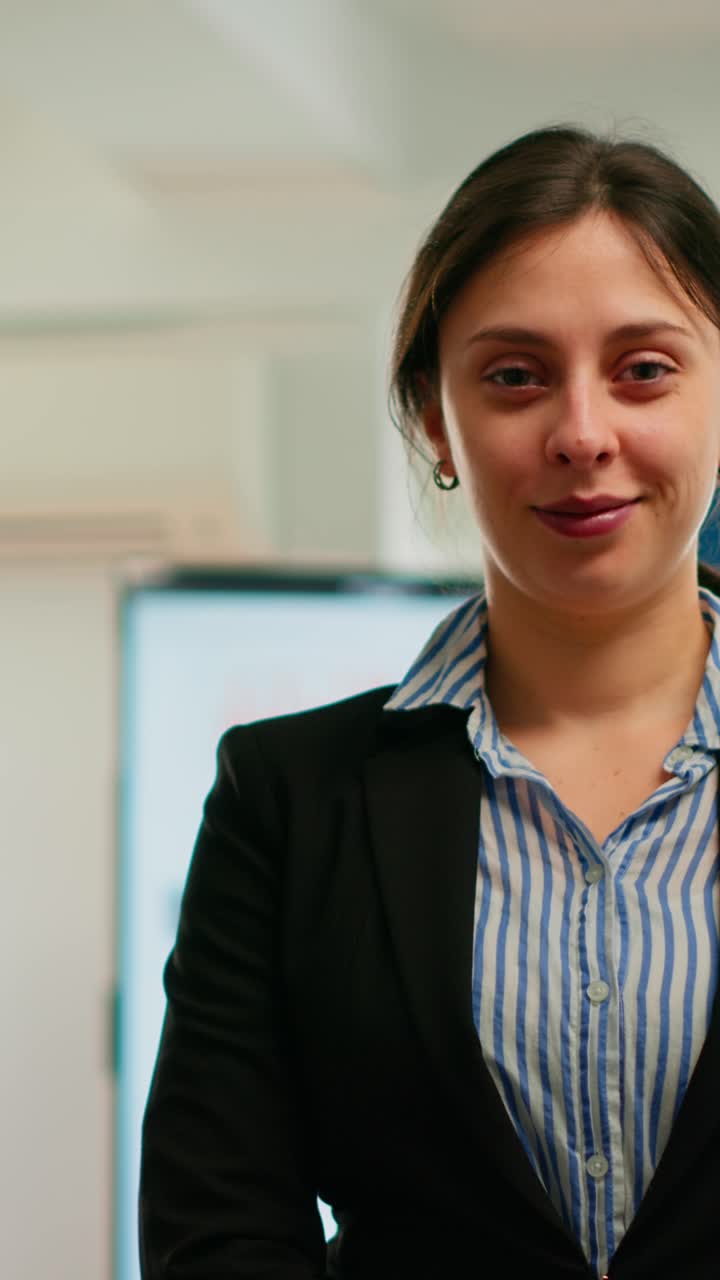 Vertical video Woman entrepreneur smiling at camera standing in conference room