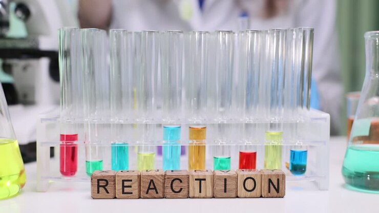 Wooden blocks spell reaction near rack of colorful test tubes