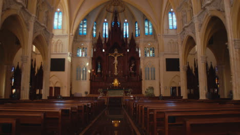 la iglesia es grande y nueva con filas vacías de asientos y una estatua de dios en el medio