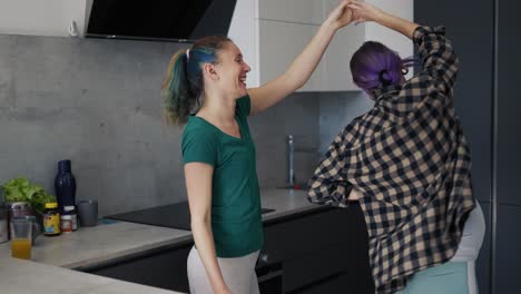 Pregnant-woman-and-her-mother-in-kitchen-have-fun-and-dancing