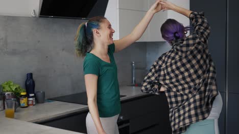 pregnant woman and her mother in kitchen have fun and dancing