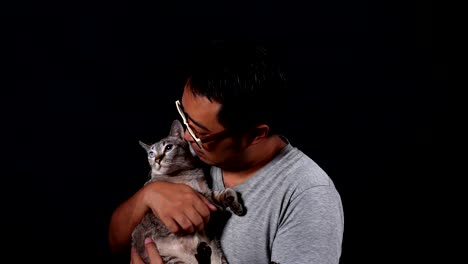 man carry and playing a cat with care. on black background