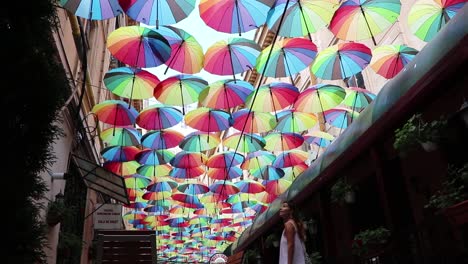 Beautiful-Girl-Looking-At-Colored-Umbrellas-And-Smiling
