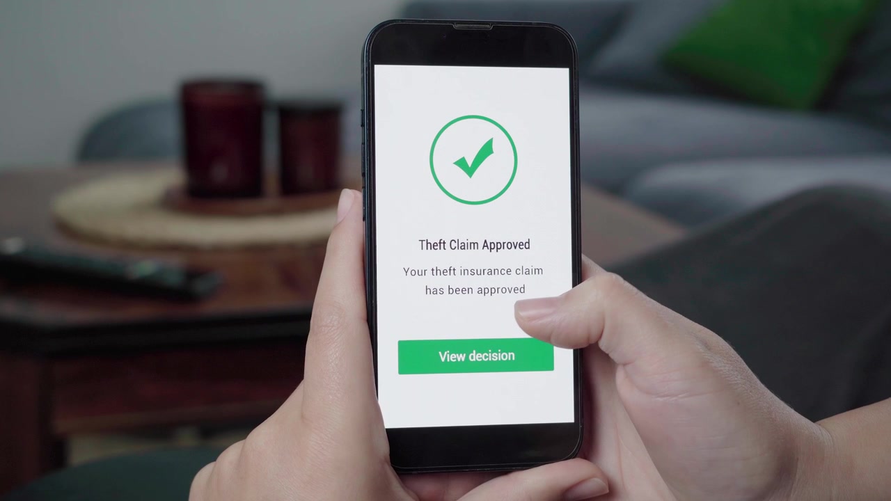 Una persona controlla un'app informativa AI che mostra un messaggio "Richiesta di furto approvata" con un segno di spunta verde e un pulsante "Visualizza decisione".