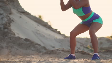 close-up of a girl with a rope conducts outdoor training on the sandy ground near the beach. rope in the hands of women at sunset