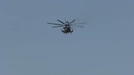 helicóptero de carga militar vuela a través de cielos azules