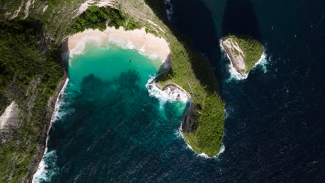 Aerial-drone-descending-view-of-Kelingking-Beach-of-Nusa-Penida-island,-Bali-in-Indonesia