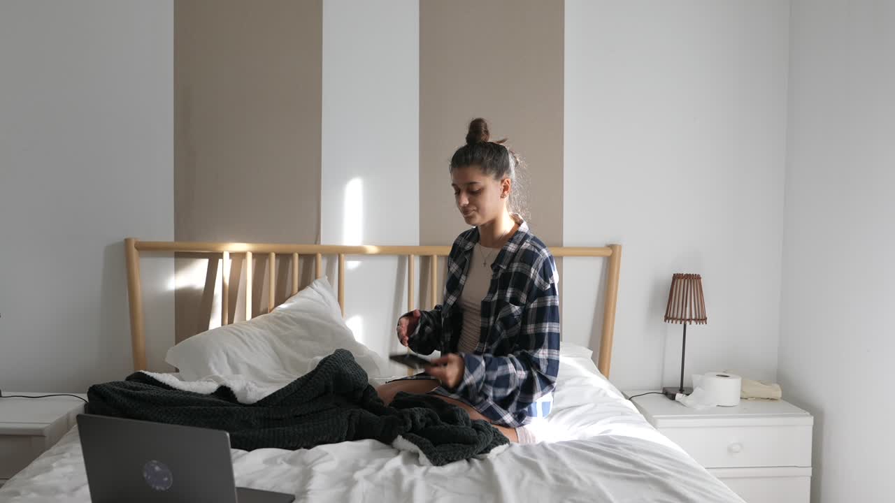 Woman Sitting in Bed Using Phone