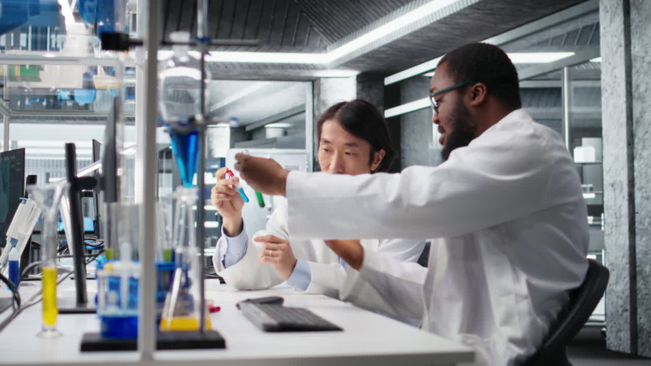 Vertical video Multiracial lab engineers inspect liquids in test tube