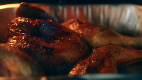 browned roast chicken cooking in an oven in a tin baking tray