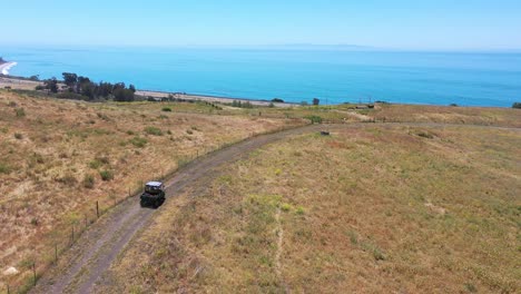 Los-Ganaderos-Aéreos-Conducen-Atv-A-Lo-Largo-De-La-Cresta-De-Un-Rancho-En-La-Costa-De-Gaviota,-Cerca-De-Santa-Bárbara,-California