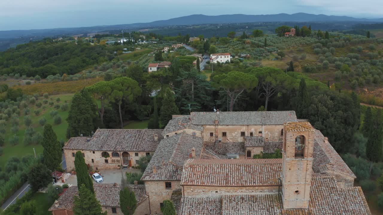 포도원, 언덕, 올리브 나무가 있는 이탈리아 토스카나의 목가적인 풍경에 있는 시에나 근처의 산지미냐노 근처에 있는 오래된 부동산의 공중 드론 영상