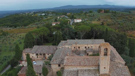 Drohnenaufnahmen-Aus-Der-Luft-Eines-Alten-Anwesens-In-Der-Nähe-Von-San-Gimignano-In-Der-Nähe-Von-Siena-In-Der-Idyllischen-Landschaft-Der-Toskana,-Italien,-Mit-Weinbergen,-Hügeln-Und-Olivenbäumen