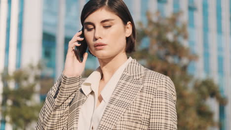 Mujer-Elegante-Haciendo-Una-Llamada-De-Negocios-Al-Aire-Libre.