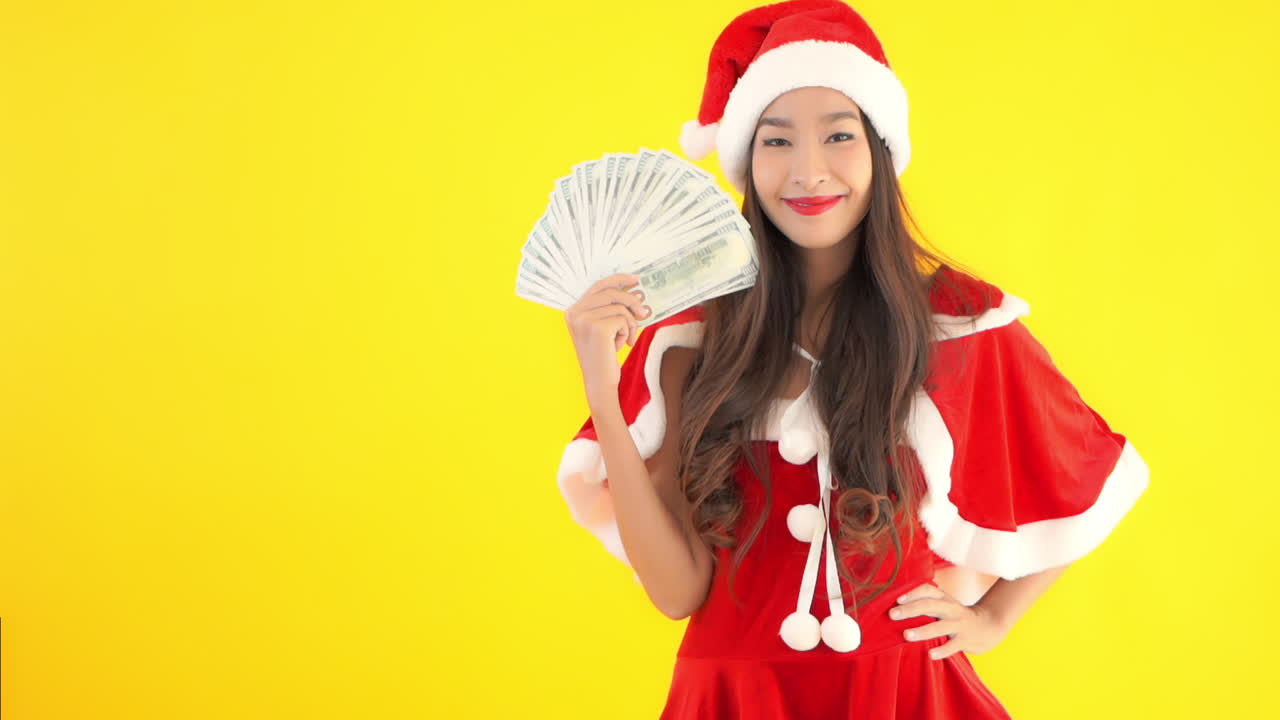 Santa's helper fans herself with a spread of one hundred dollar bills