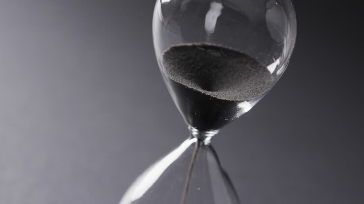 Video of hourglass with sand pouring, copy space on grey background