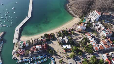 Aerial-view-of-Santa-Cruz-Bay-in-Huatulco,-Oaxaca,-showcasing-the-beach-and-people