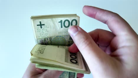 manos de un hombre de negocios contando billetes de cien zloty