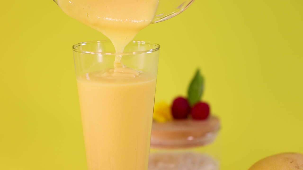 Mango smoothie with raspberries and yellow flower