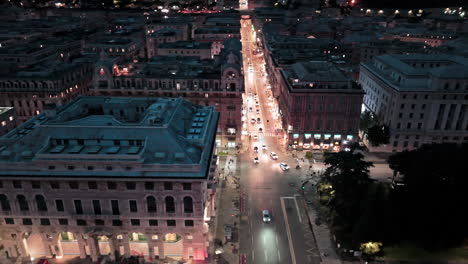 illuminated via xx settembre with car traffic in historic genova, italy. aerial