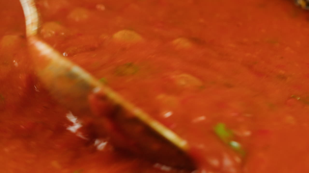 Chicken in tomato sauce is boiling on a frying pan with spices. Cooking tomato sauce curry with chicken fillet. Traditional Italian Mexican Asian dish. High quality studio shot for cafe, restaurant close up.