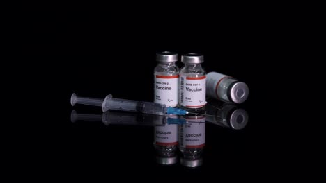 Vaccine-bottles-of-Sars-cov-2-or-Coronavirus-with-syringe-on-black-background