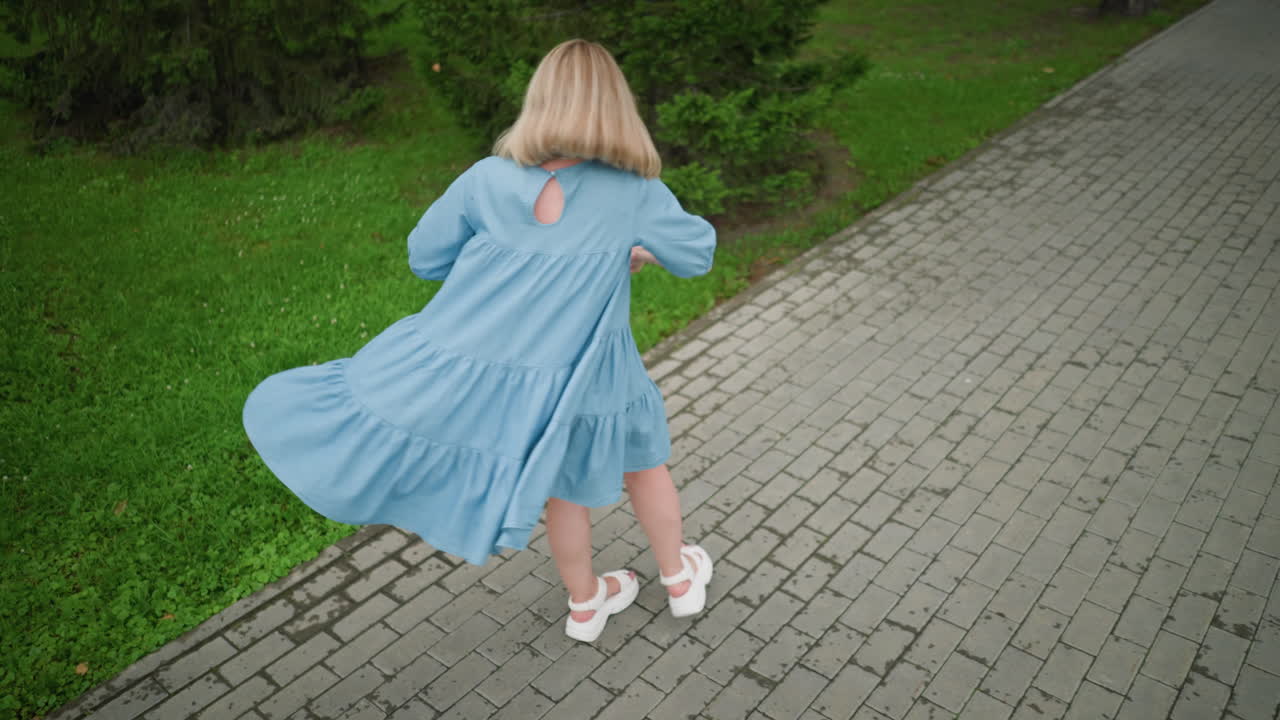 어머니와 그녀의 아이가 기으로 그를 회전시키면서 놀이하는 순간, 그들은 활기차고 울창한 녹색 배경으로 둘러싸여 있습니다.