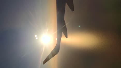 silhouette of the wing of an airplane in line with the horizon during sunrise