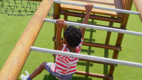 vista de alto ángulo de un escolar afroamericano jugando en una escalera horizontal en el patio de recreo de la escuela 4k