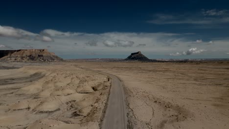 Distant-buttes-in-a-barren-desert-wasteland---aerial-view