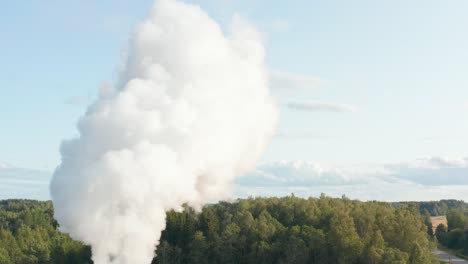 Luftdrohnenaufnahme-Eines-Fabrikschornsteins,-Der-In-Ländlicher-Gegend-Dämpfe-In-Die-Atmosphäre-Spuckt