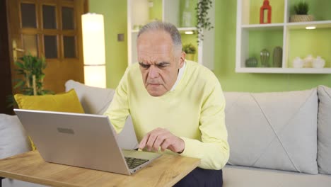 Old-man-using-laptop-at-home-and-struggling.