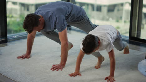 sporty father and son training together. dad and child doing workout at home.