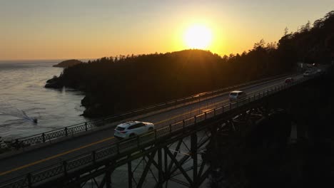 Drohnenschuss,-Der-über-Den-Kanupass-An-Der-Deception-Pass-Bridge-Fährt,-Mit-Autos,-Die-Darunter-Pendeln