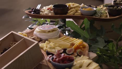 Assorted cheese platter with fruits nuts and olives on a rustic wooden board