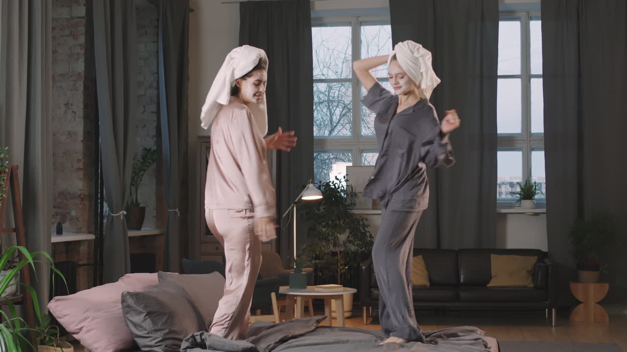 Female Best Friends Dancing On Bed