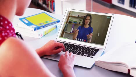 chica caucásica usando una computadora portátil mientras tiene una llamada de video en la computadora portatal con una maestra