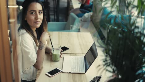 mujer joven seria que trabaja en una computadora portátil