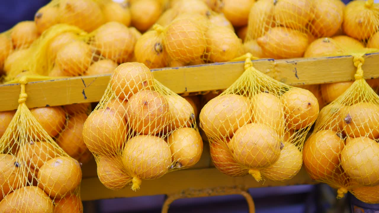 Yellow Lemons in Net Bags at a Market
